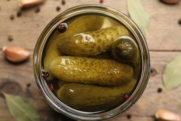 Tasty pickled cucumbers in glass jar on table, top view