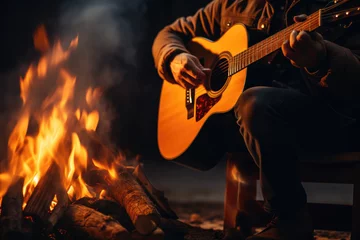 Fototapeten A person playing acoustic guitar by a campfire, capturing the essence of music and outdoor relaxation. Generative Ai. © Sebastian