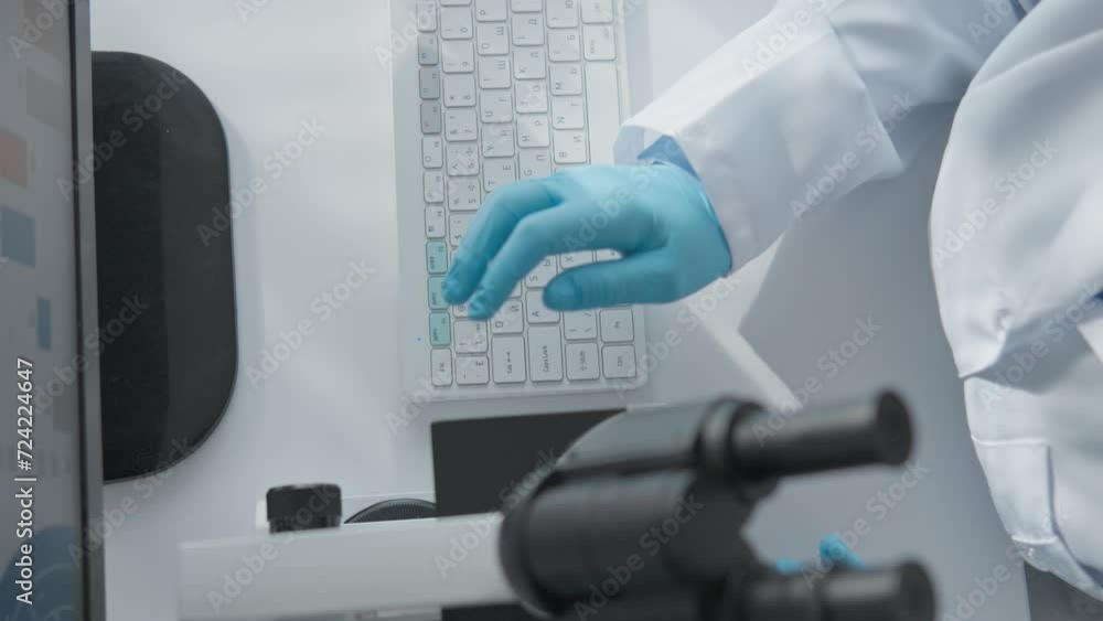Poster The scientist works at the keyboard and at the computer at the table. Woman looking through microscope in research laboratory A medical professional analyzes and studies chemical preparations