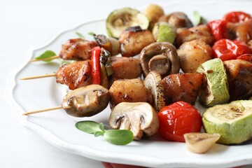 Delicious shish kebabs with vegetables and microgreens on table, closeup
