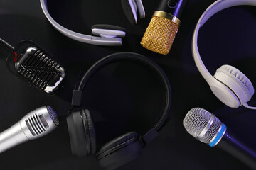 Different microphones and headphones on dark background, flat lay. Sound recording and reinforcement