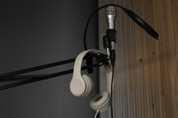 Stand with microphone, headphones and pop filter indoors. Sound recording and reinforcement