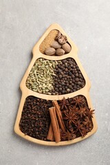 Different spices and nuts on gray textured table, top view