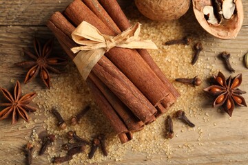 Different spices and nuts on wooden table, flat lay