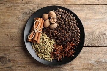 Fototapeta na wymiar Different spices and nuts on wooden table, top view