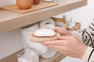 Bath accessories. Woman with soap indoors, closeup