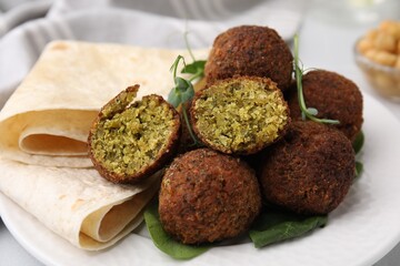 Delicious falafel balls, herbs and lavash on plate, closeup