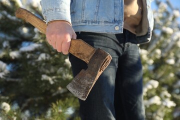 Man with axe outdoors on sunny winter day, closeup