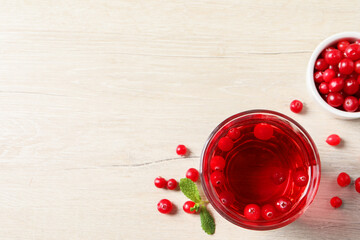 Tasty refreshing cranberry juice, mint and fresh berries on light wooden table, flat lay. Space for text
