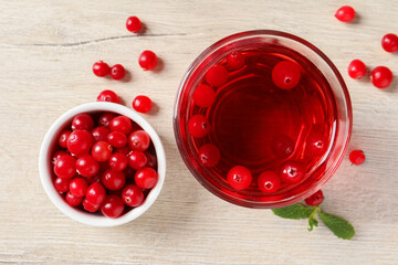 Tasty refreshing cranberry juice, mint and fresh berries on light wooden table, flat lay