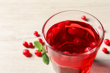 Tasty refreshing cranberry juice, mint and fresh berries on light wooden table, closeup. Space for text
