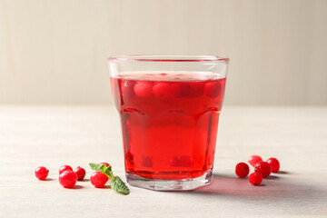 Tasty refreshing cranberry juice, mint and fresh berries on light wooden table
