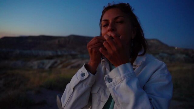 beautiful girl shaman plays the jew's harp at sunset