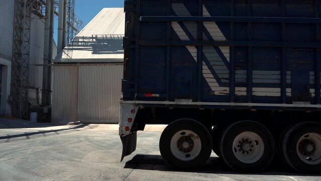 trailer camion de carga circulando de reversa en industria bodega almacén de granos para descargar la mercancía