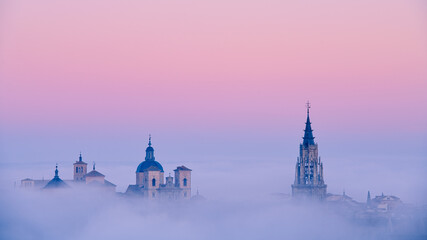 Foggy sunrise over historical buildings