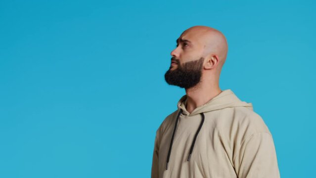 Arab man exploring artificial intelligence with holograms, examining holographic projection of a slideshow in studio. Middle eastern person looks at graphic image on holograph. Camera 2.