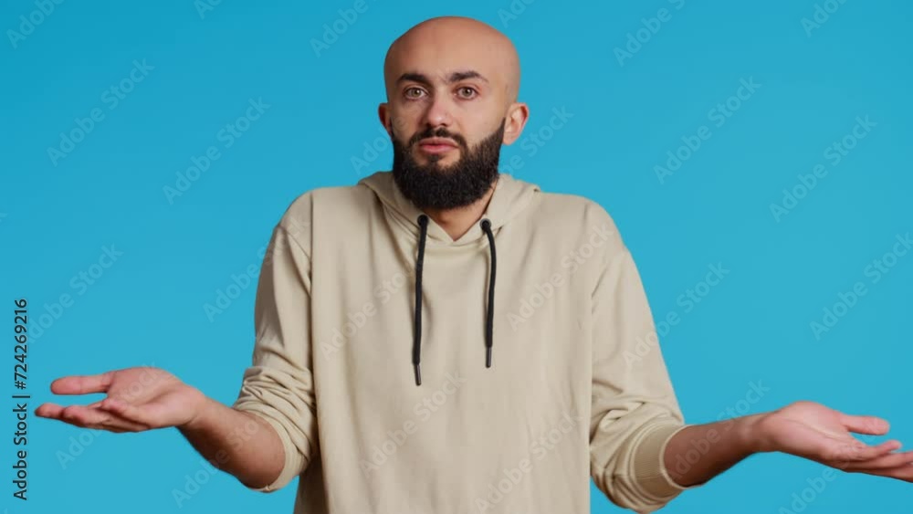 Poster middle eastern guy showing i dont know gesture in studio, being clueless and uncertain about answer 