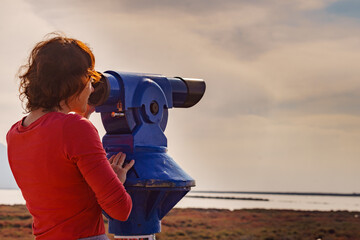 Woman using tourist binoculars, Cabo de Gata, Spain
