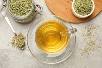 Aromatic fennel tea and seeds on light grey table, flat lay