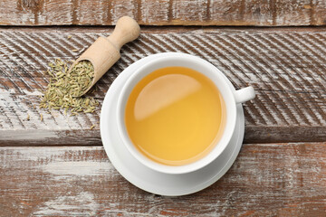 Aromatic fennel tea, seeds and scoop on wooden table, top view