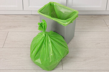 Plastic garbage bag and trash can indoors