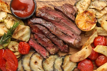 Delicious grilled beef with vegetables, rosemary and tomato sauce on table, top view
