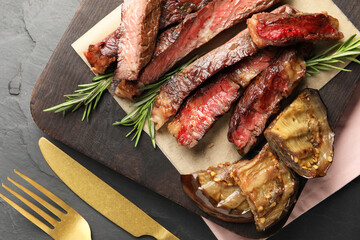 Delicious grilled beef with eggplant and rosemary served on table, top view