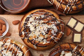 Delicious rolls with toppings and nuts on table, top view. Sweet buns