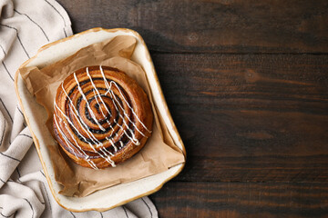 Sweet bun. Delicious roll with topping and poppy seeds on wooden table, top view. Space for text
