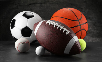 Many different sports balls on dark gray background
