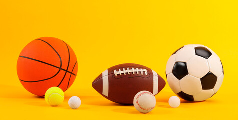 Many different sports balls on yellow background. Banner design
