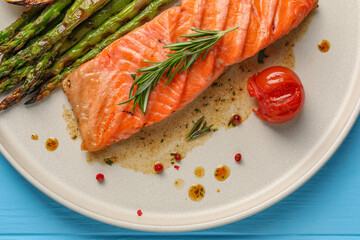 Tasty grilled salmon with tomato, asparagus and spices on table, top view