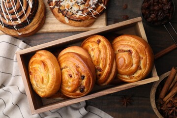 Different delicious rolls on wooden table, flat lay. Sweet buns
