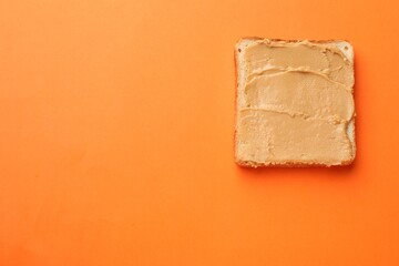 Tasty peanut butter sandwich on orange background, top view. Space for text