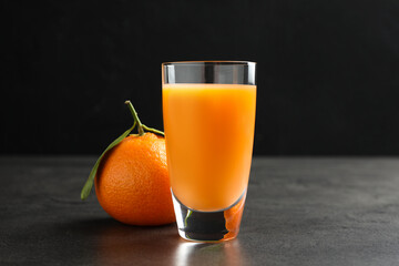 Delicious tangerine liqueur and fresh fruit on grey table