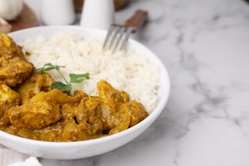 Delicious chicken curry with rice on white marble table, closeup