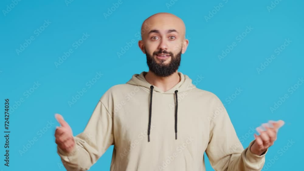 Poster middle eastern guy pointing down to show something, trying to explain by looking down at his feet. a