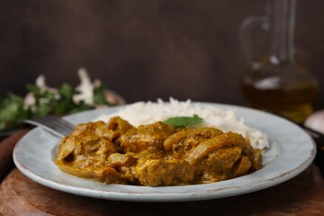 Delicious chicken curry with rice on wooden table, closeup