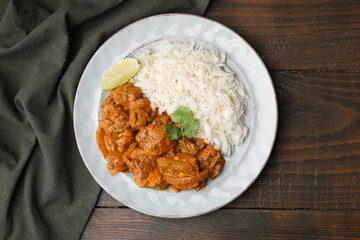 Delicious chicken curry with rice on wooden table, top view