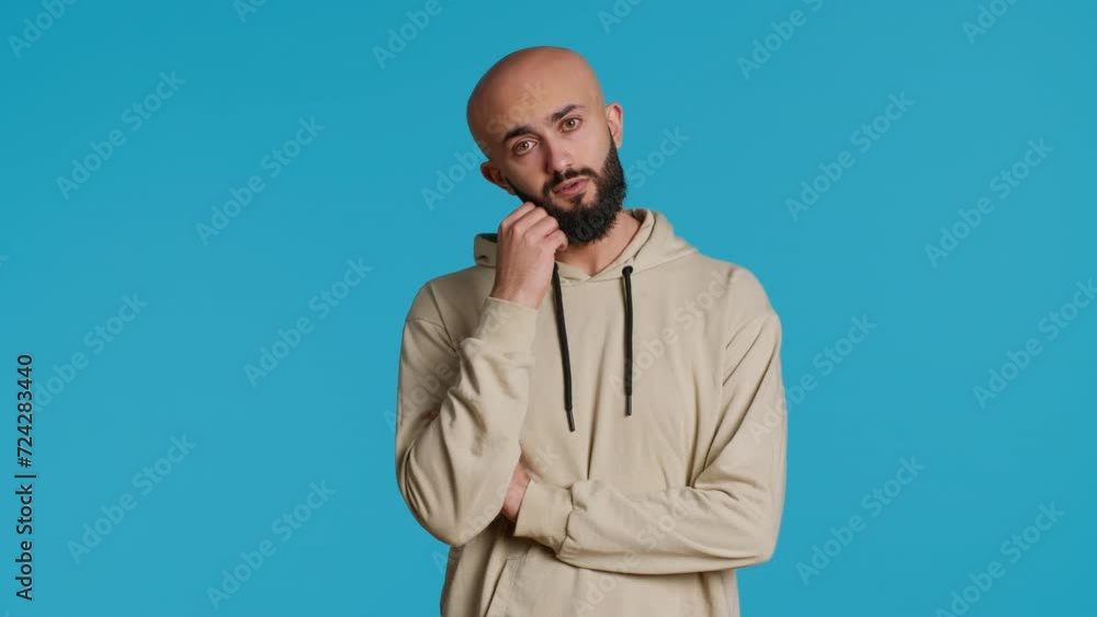 Poster middle eastern person thinking about a thing on camera, acting pensive and puzzled while trying to m