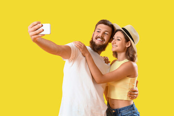 Happy couple in love taking selfie on yellow background