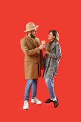 Happy couple in love with cups of coffee on red background