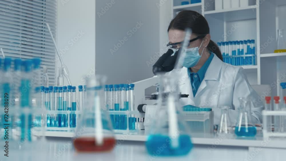 Poster A researcher deeply immersed in the study of the microscopic world works at a microscope, using technology to analyze structures and cellular processes in a modern chemistry laboratory