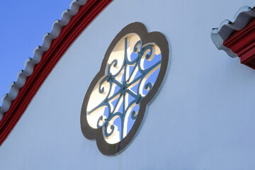 Symmetrical architectural decorative detail and openwork in the shape of a clover on the facade of a house 