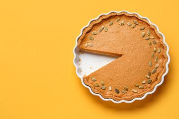 Baking dish with tasty pumpkin pie on yellow background