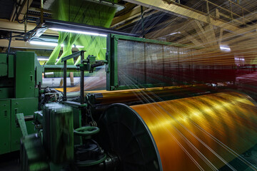 Synthetic yarns for carpet factory, carpet production, weaving looms. Interior of a Carpet Weaving Factory. Spool Sewing Thread Rack at Textile Weaving Mill. - obrazy, fototapety, plakaty