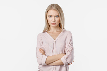 Portrait of angry woman standing with arms folded on white background. Negative emotion of sad...