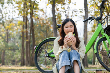 Young woman eating meal at park.