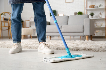 Woman mopping floor in living room