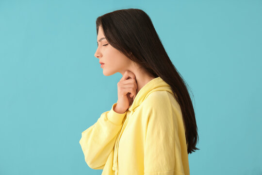 Young woman with thyroid gland problem on blue background